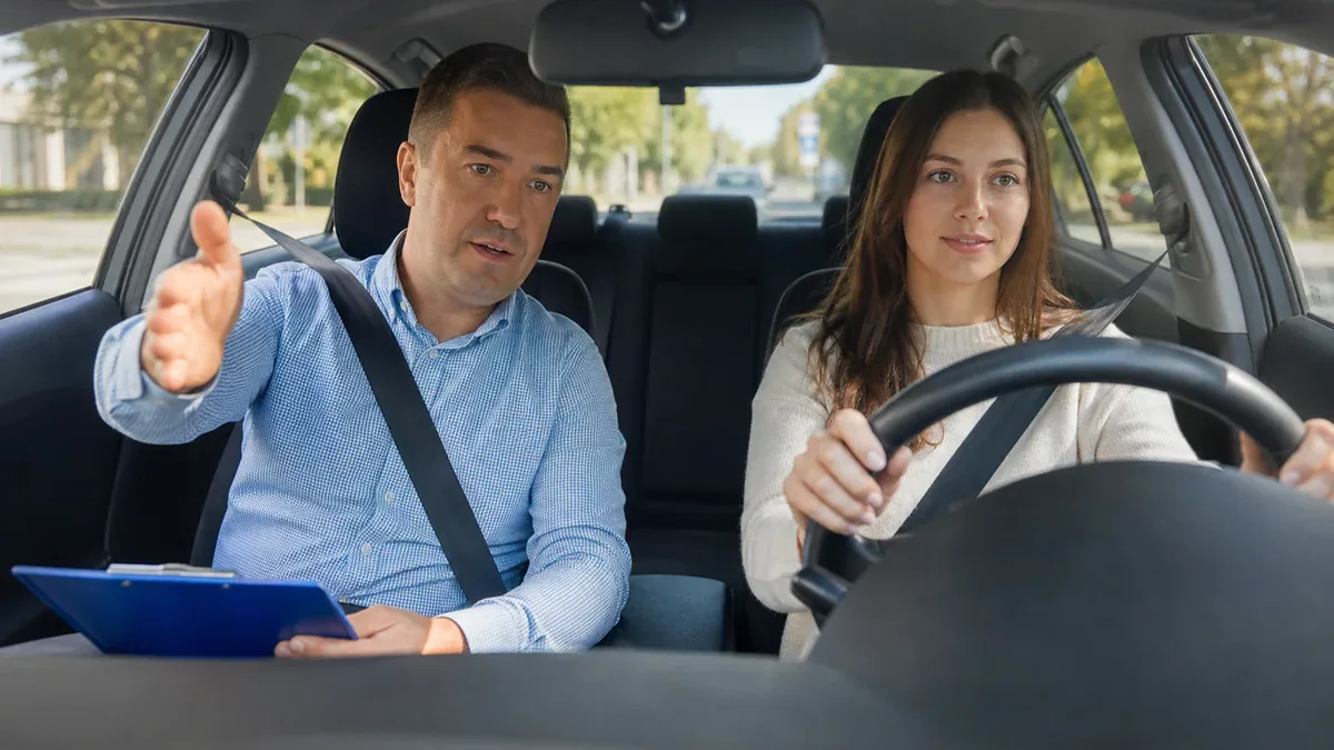 Инструктор обучает водителя в учебном автомобиле